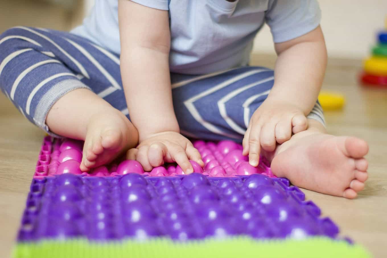 małe dziecko siedzące na macie sensorycznej